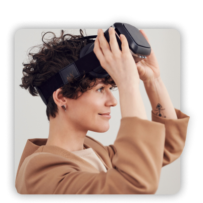 Woman smiling while putting on a VR headset.