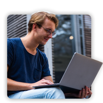 Startup employee smiling while working on his laptop.