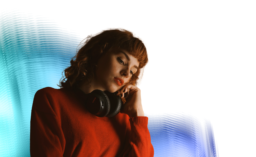 A woman with red hair and headphones around her neck.